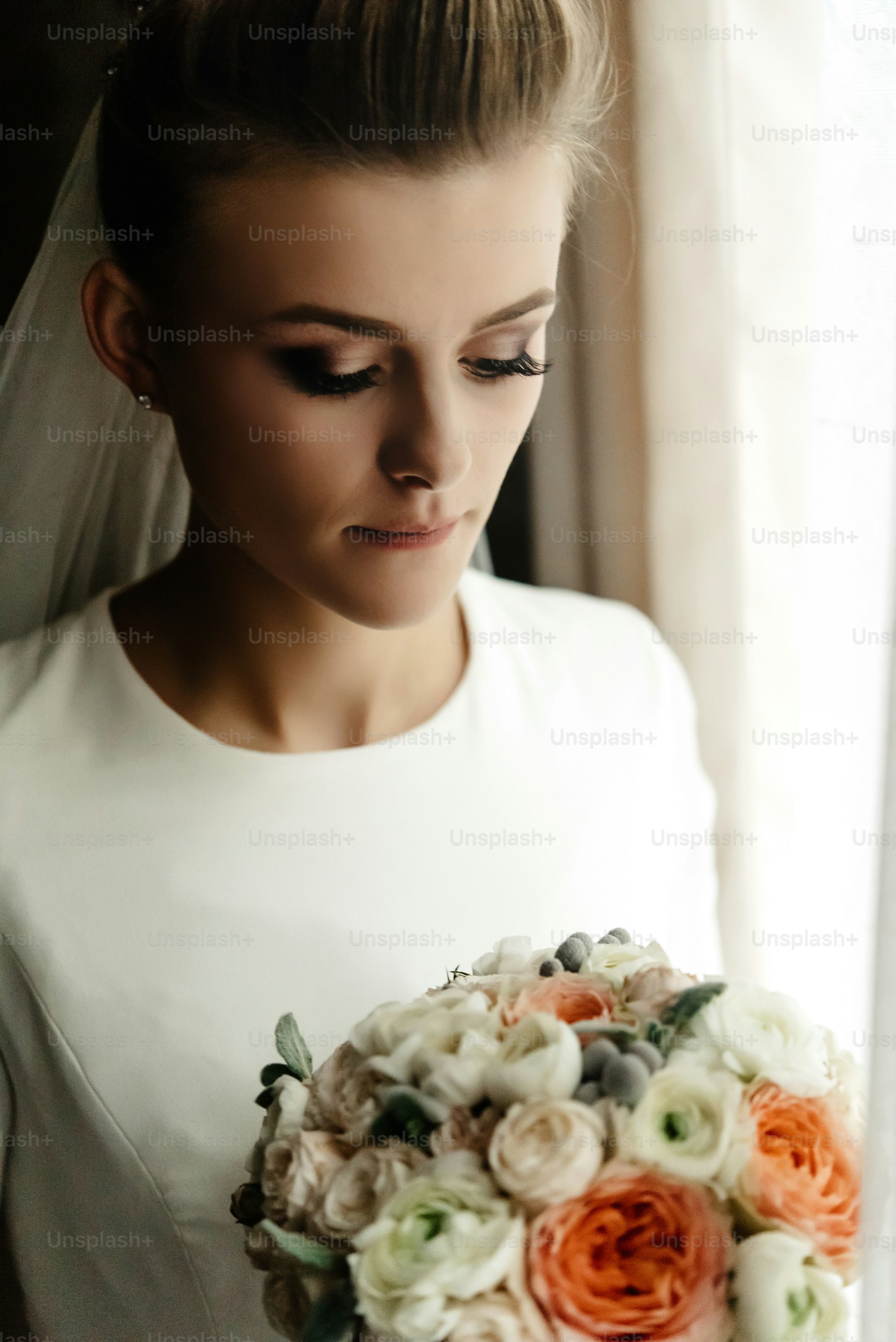beautiful elegant bride holding luxury bouquet near window in room, organic wedding