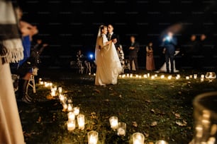 gorgeous bride and stylish groom having their first dance at romantic candle light at evening wedding ceremony