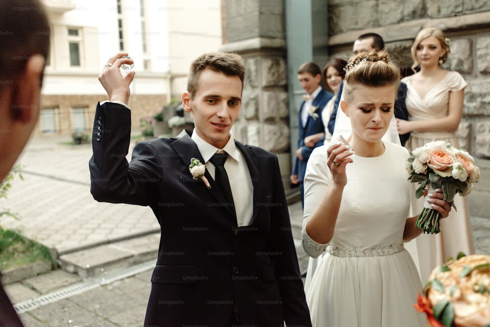 sposa e sposo felici che brindano e ridono, momento divertente, splendido ricevimento di nozze