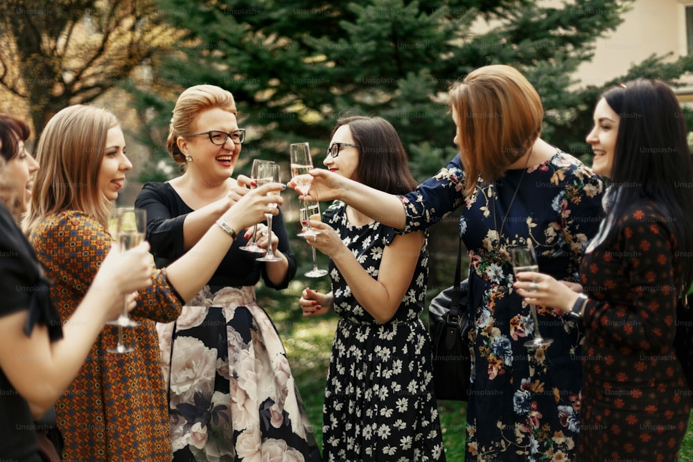 Gruppo di donne eleganti di lusso che celebrano e scattano con champagne, felicità di momento allegro