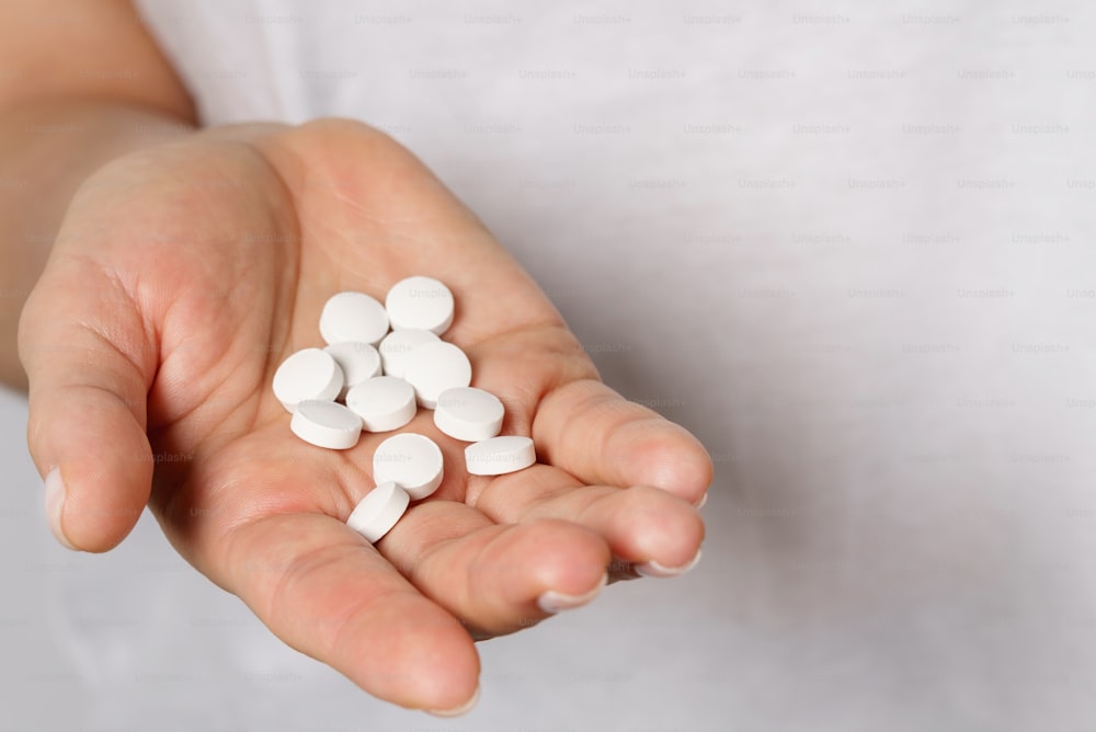 Close up of female hand with a handful of pills