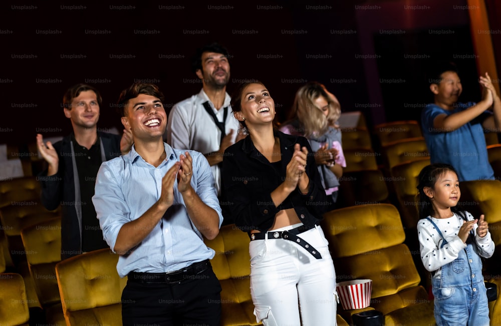 Grupo de público feliz e divertido assiste cinema no cinema. Atividade de recreação em grupo e conceito de entretenimento.