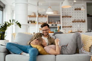 Young loving couple in sofa. Happy couple relaxing in living room..
