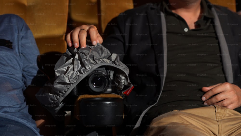 A man is secretly filming a video while watching a movie at the cinema