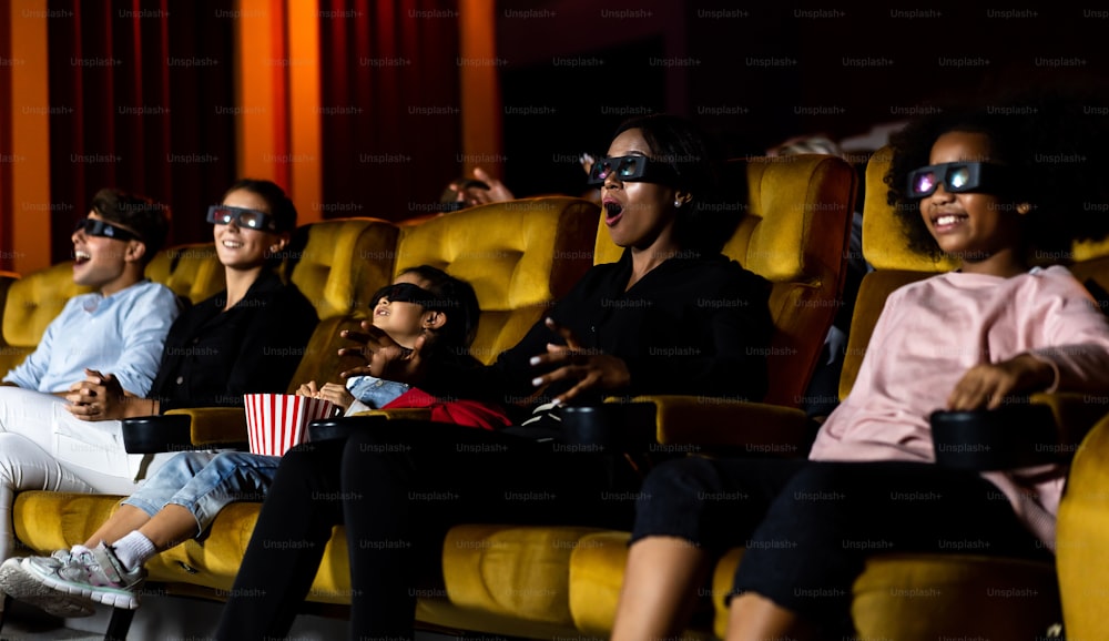 사람들의 그룹은 화면을 보고 흥미진진하고 즐길 수 있는 영화관에서 3D 안경으로 영화를 봅니다.