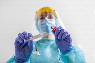 Female caucasian doctor holding a swab collection stick, nasal and oral specimen swabbing , patient PCR testing procedure appointment, Coronavirus COVID-19 global pandemic crisis