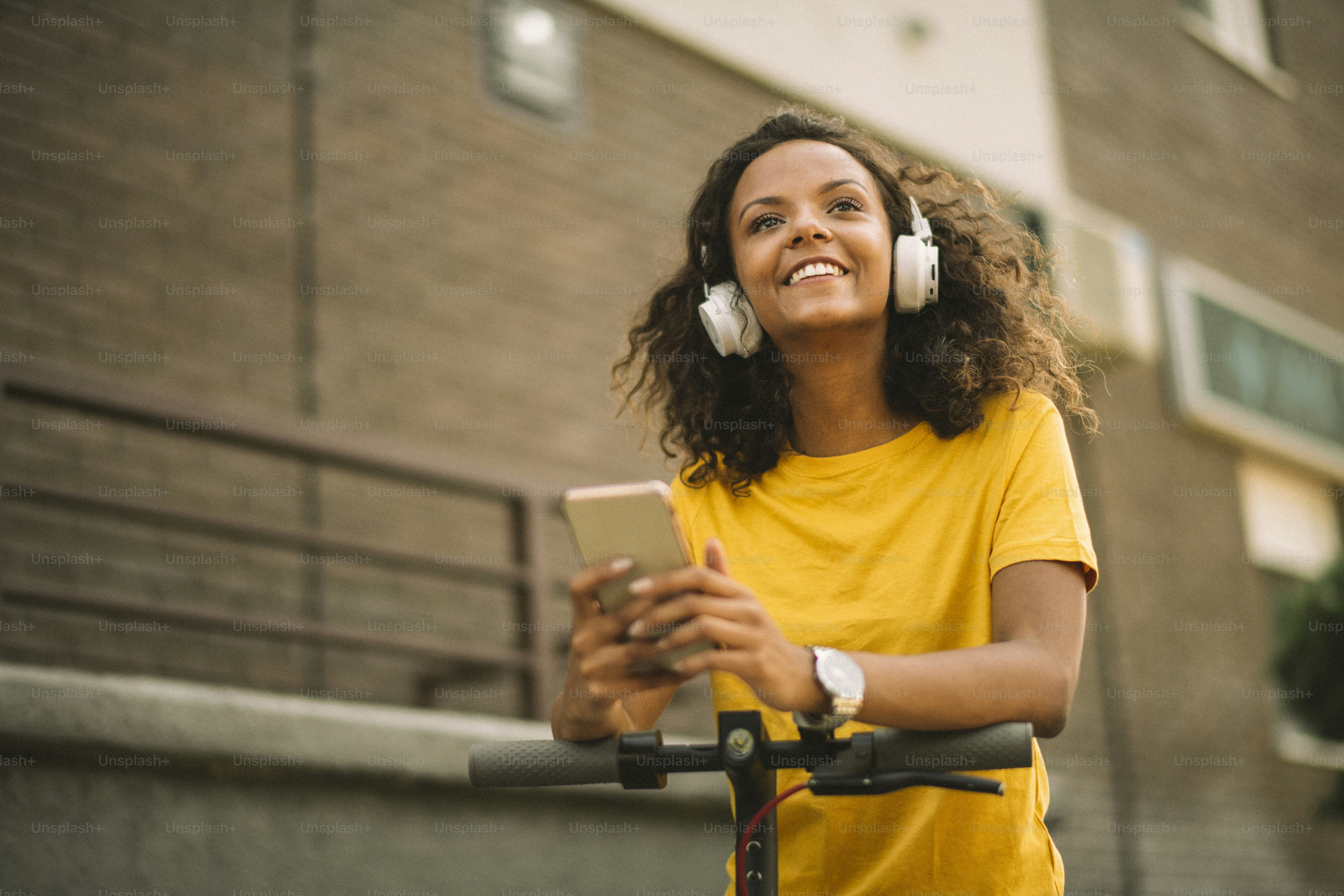 Beautiful african girl using phone on electric scooter.