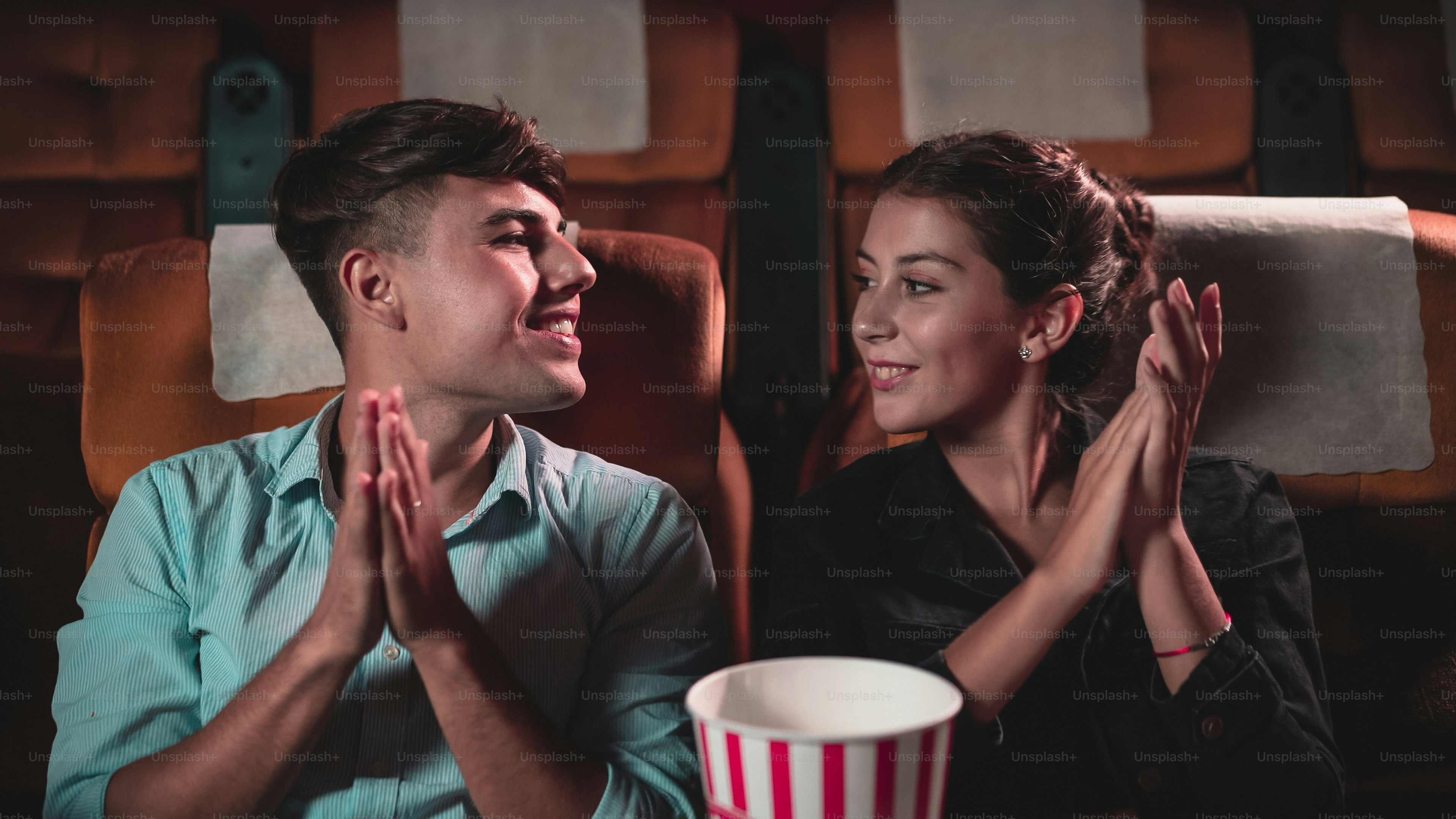 Man and woman applauding enthusiastically at the end of a performance and walk away