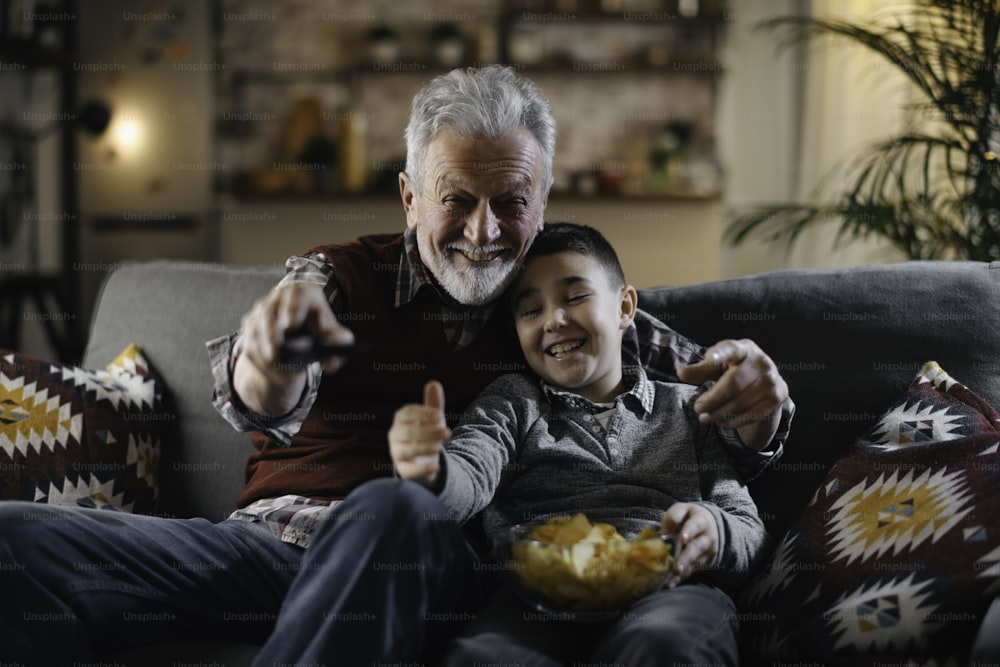 Großvater und Enkel beim Fernsehen. Großvater und Enkel genießen zu Hause.