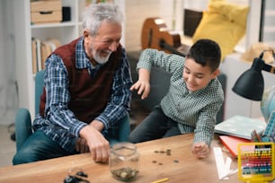 Grandpa and grandson saving money. Grandfather teaching grandchild how to save money.