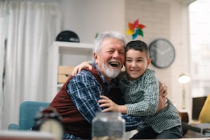 Grandpa and grandson saving money. Grandfather teaching grandchild how to save money.