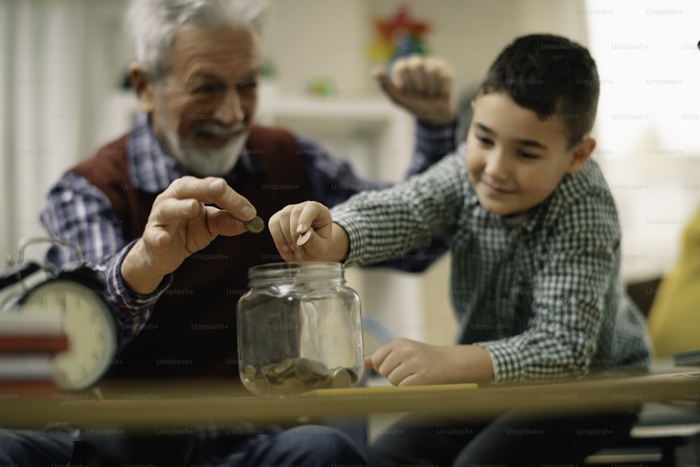 Nonno e nipote risparmiano. Nonno che insegna al nipote come risparmiare denaro.