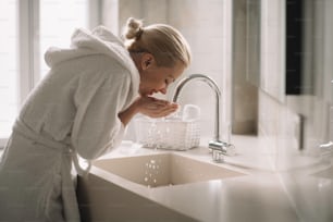 Beautiful woman wearing a bathrobe. Young happy woman enjoing in hotelroom.