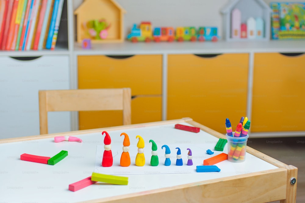 Gnomos coloridos de argila de brincadeira de criança na mesa na sala das crianças. Atividades em casa para a família.