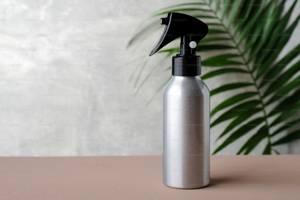 Botella de spray para el cabello de gatillo plateado en blanco. Cosmética orgánica natural para el concepto de peluquería.