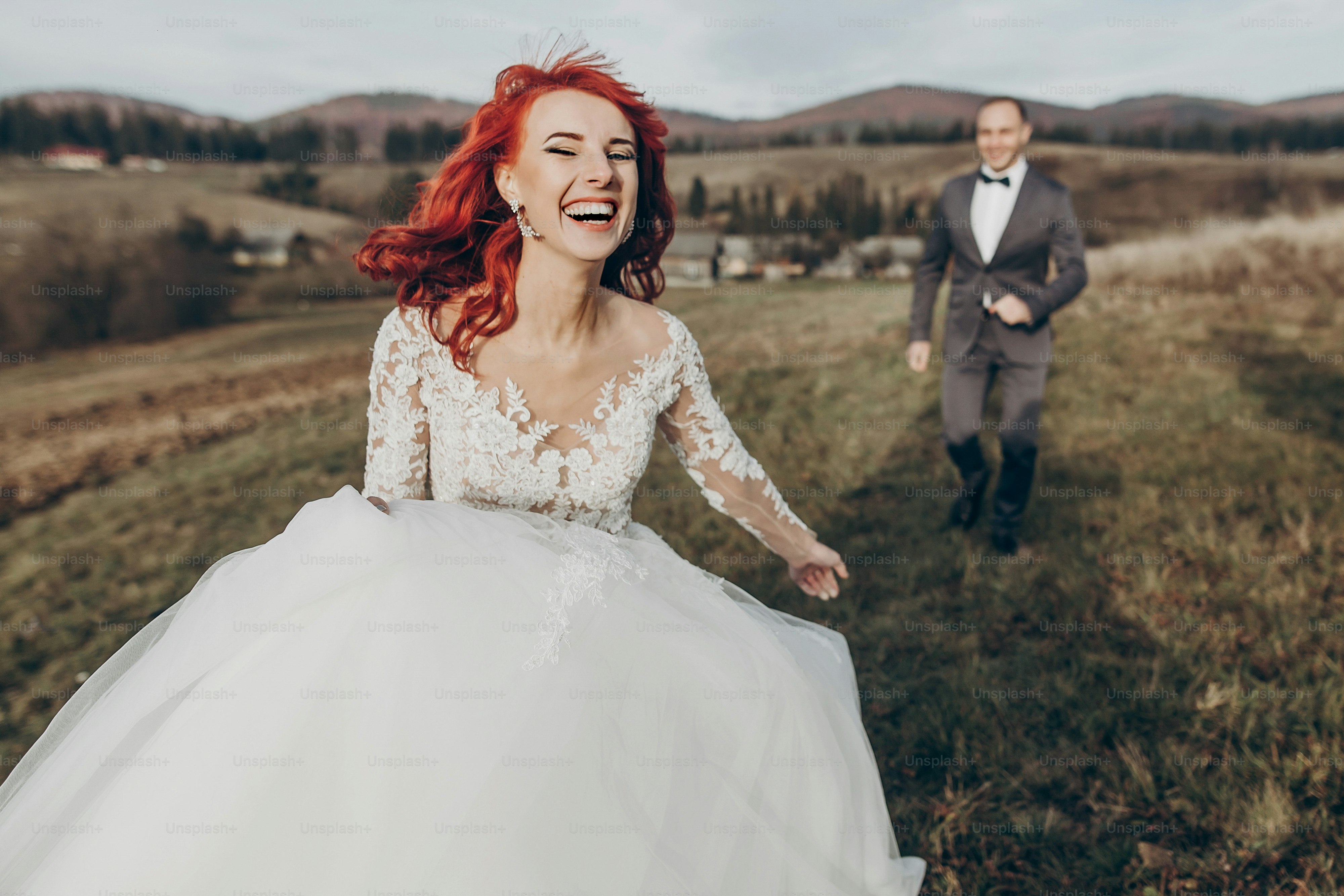 happy stylish bride and groom running and having fun in mountains at sunset light. gorgeous newlywed couple laughing, true feelings. emotional romantic moment. space for text