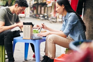 베트남에서 길거리 음식을 먹는 관광객