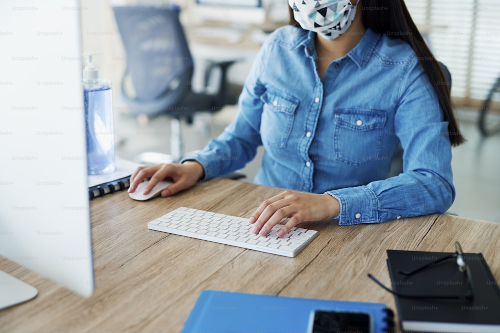 Unrecognizable person in face mask working in the office