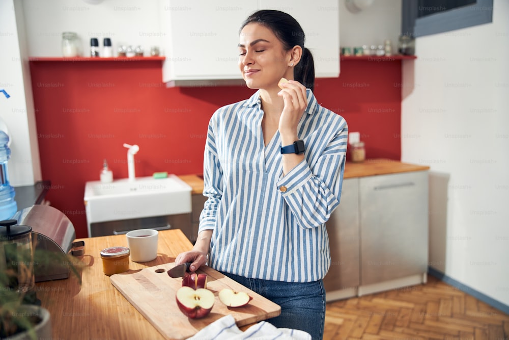 Lächelnde Dame mit Snack in der Küche Stock Foto. Lifestyle-Konzept
