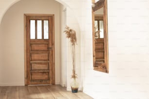 Beautiful boho interior of hallway at cozy apartment. Minimalistic Mediterranean style and design accessories. Stylish home decor.