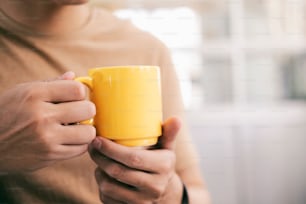 Close up man hands holding a cup of coffee.