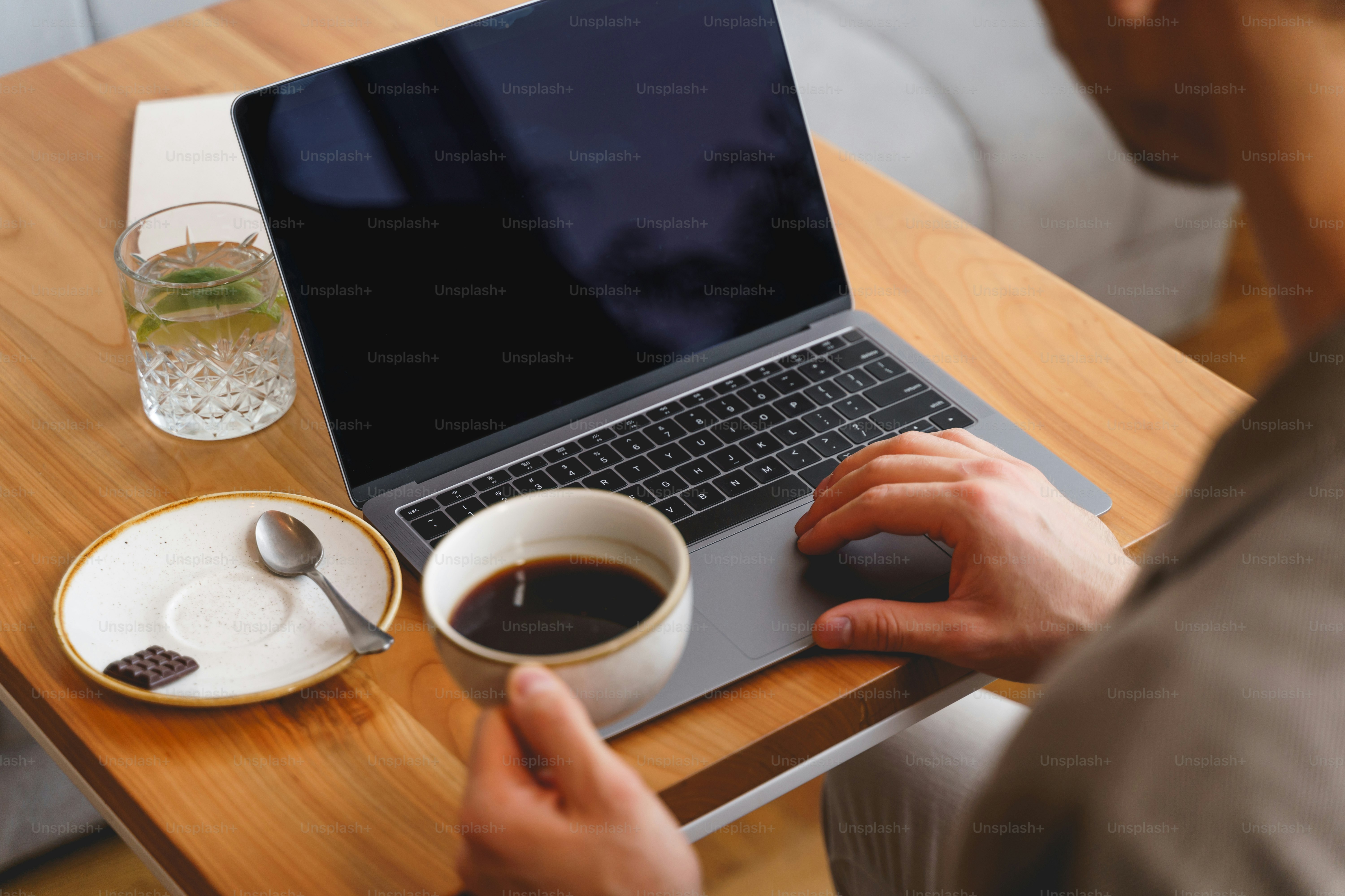 Close up of gentleman drinking coffee and working on modern notebook in cafe