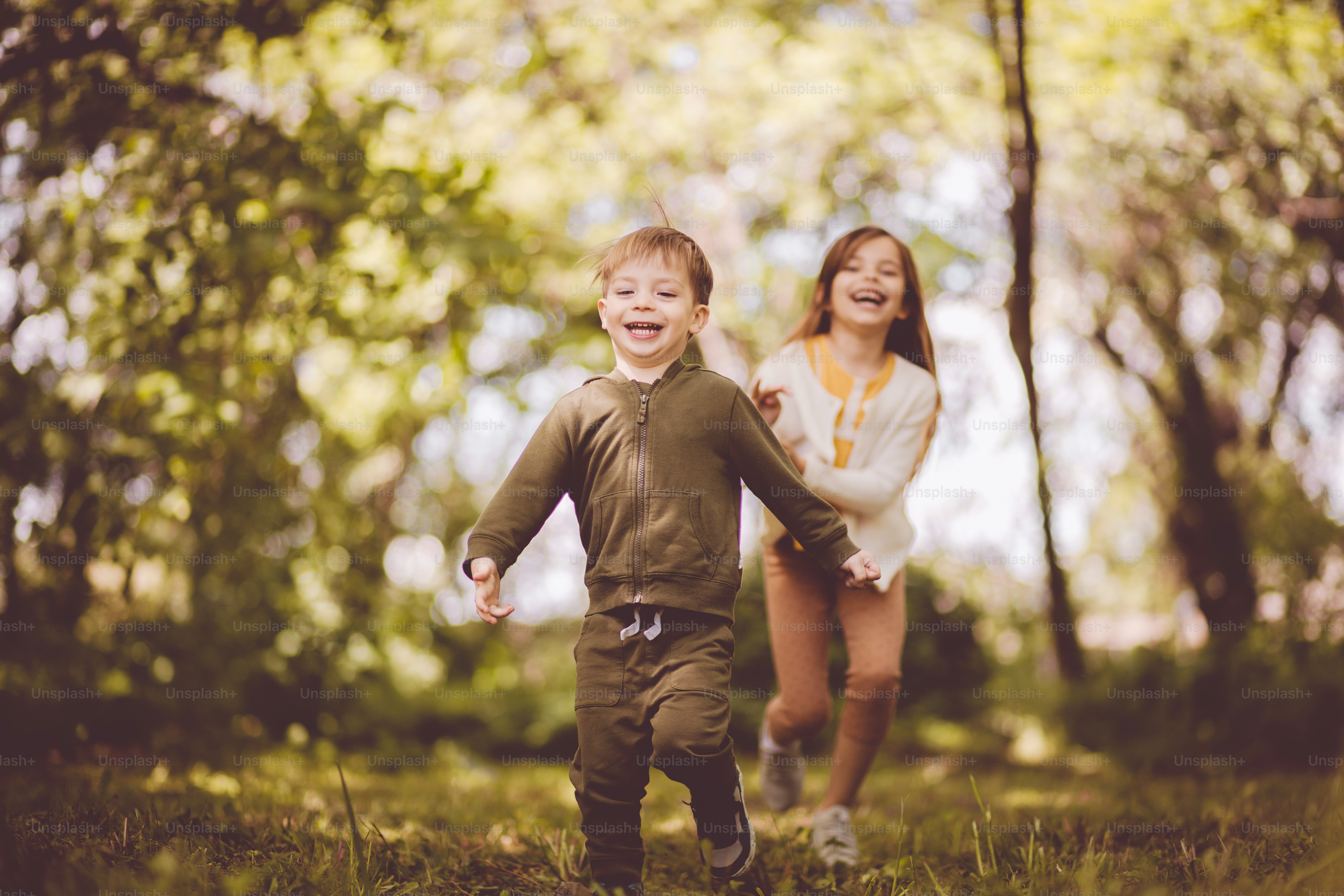 It's always fun for them. Sister and brother running trough nature. Focus is on foreground.