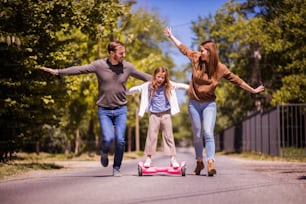 Spread your arms feel free. Parents spending time with their daughter outside.