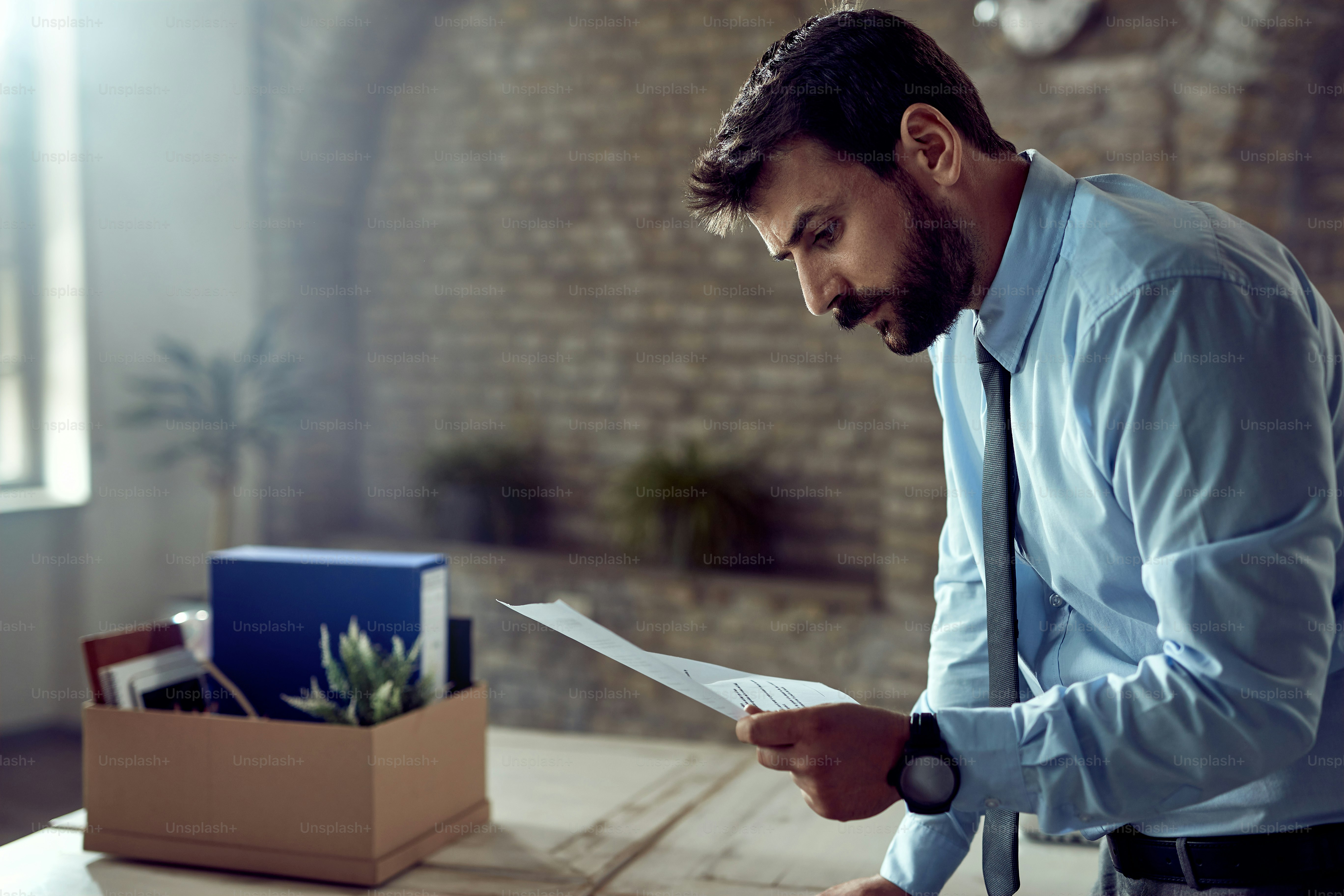 Young businessman reading the notice of dismissal from work