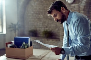 Young businessman reading the notice of dismissal from work.