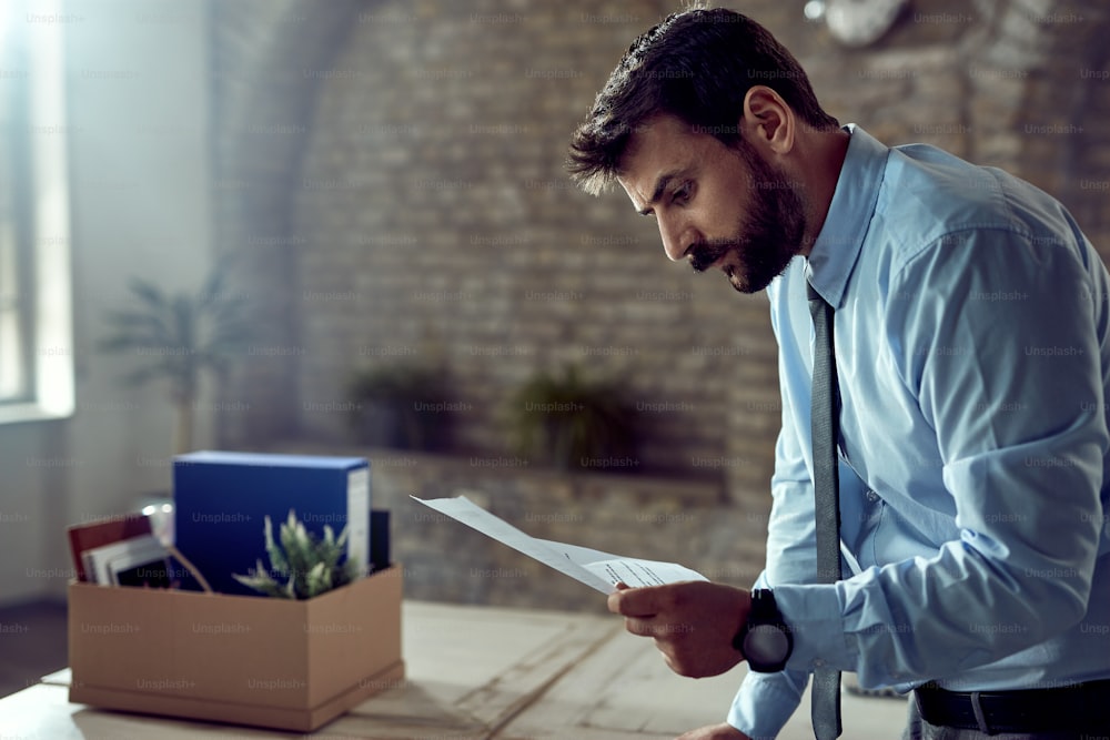 Young businessman reading the notice of dismissal from work.