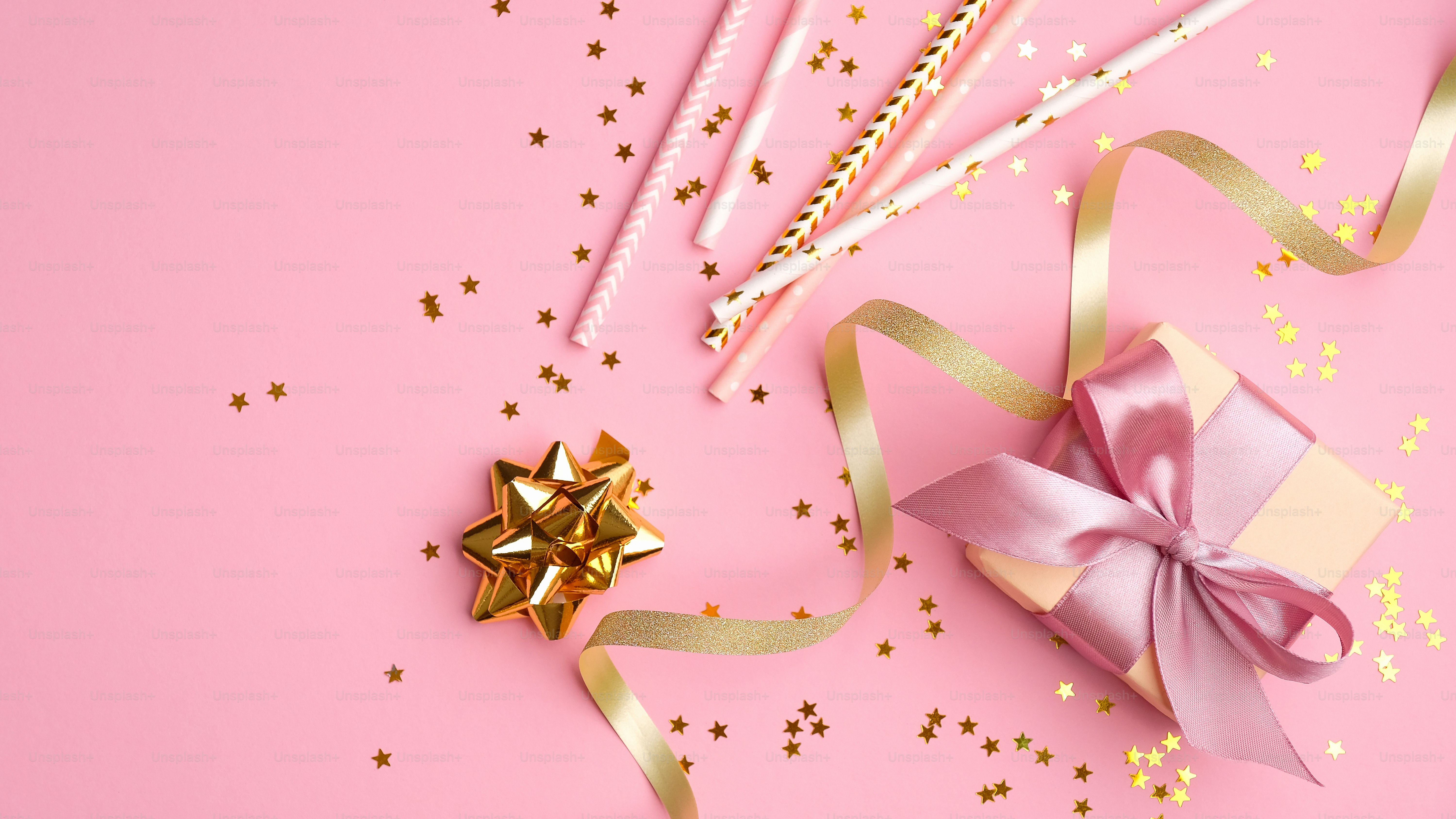 Décoration de fête d'anniversaire de filles sur fond rose vue de dessus.  Boîte-cadeau à plat, pailles à boisson, banderoles de fête dorées et  confettis. Conception d'invitation, enterrement de vie de jeune fille,, image size:3000x1688