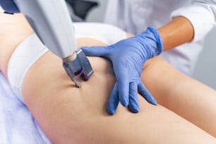 Dermatologist carrying out a non-invasive procedure on a young female patient in a beauty salon