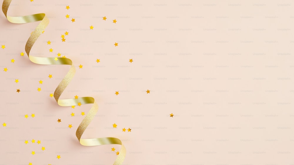 Golden spiral ribbon and confetti star on beige background. Christmas, birthday or wedding concept. Flat lay, top view.
