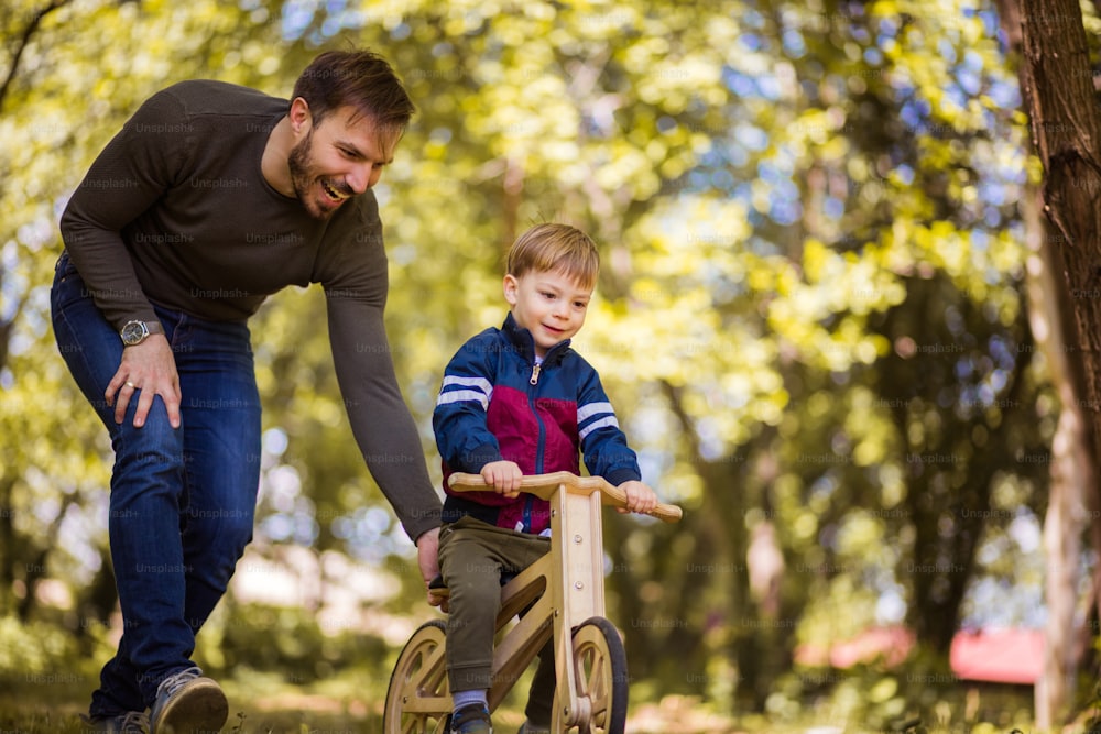Grande vínculo. O pai ensina o filho a andar de bicicleta.