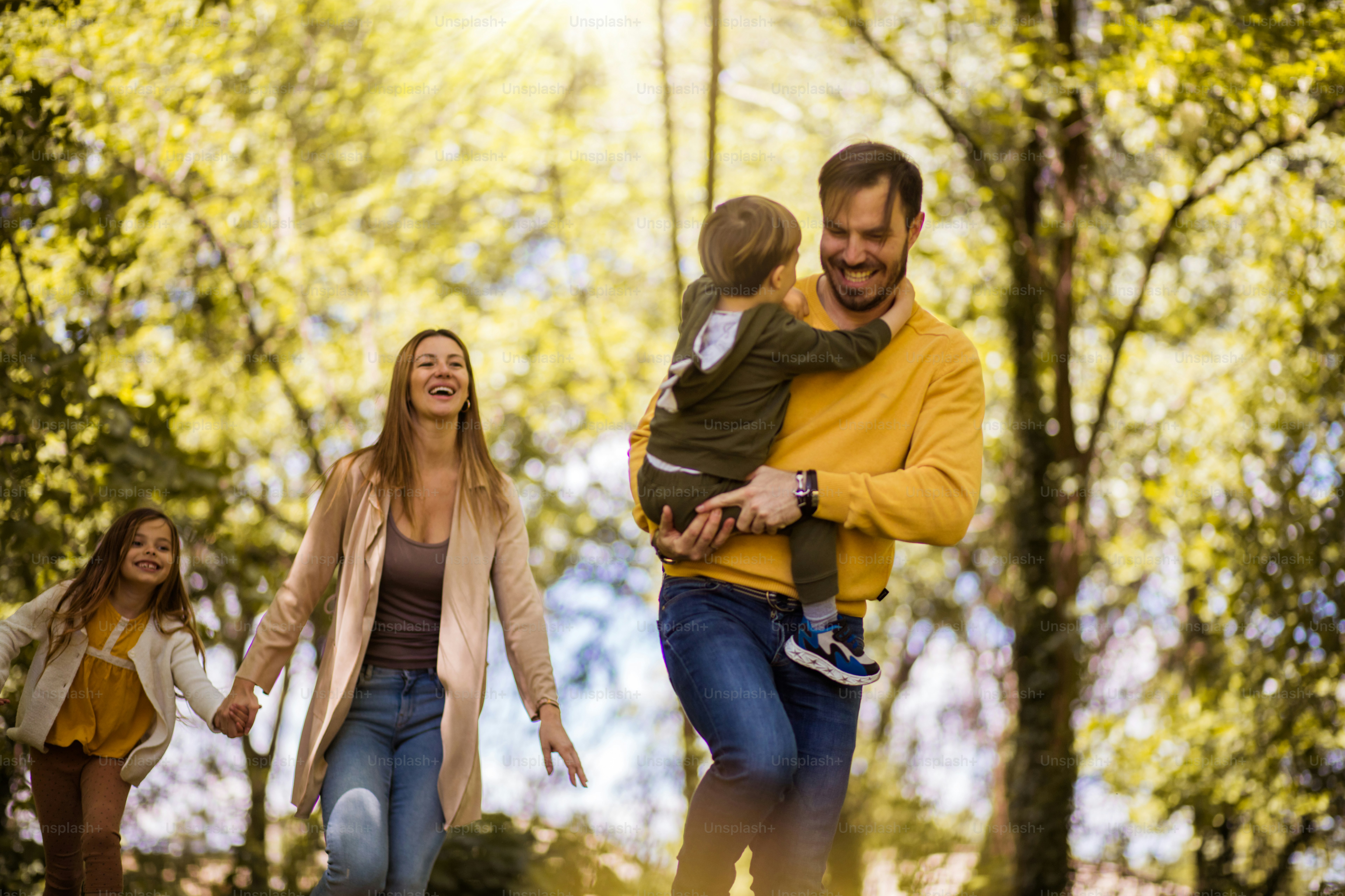 Foto zum Thema Fangen Sie uns, wenn Sie können. Eltern verbringen Zeit mit ihren Kindern draußen