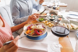 Close up of man and woman sitting at the table and eating delicious food in cafe