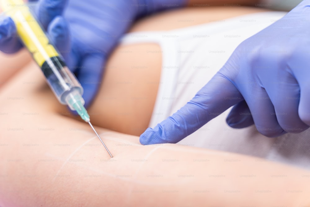 Foto cortada de um dermatologista em luvas de látex usando uma seringa descartável para uma injeção