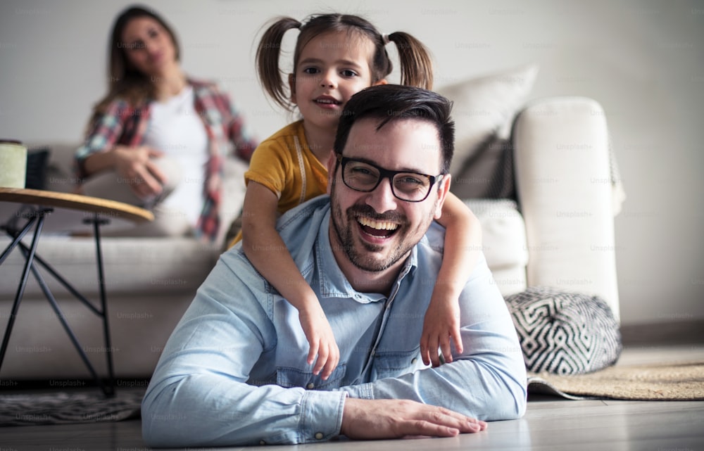 We always have fun. Family at home. Father playing with her daughter. Focus on foreground.