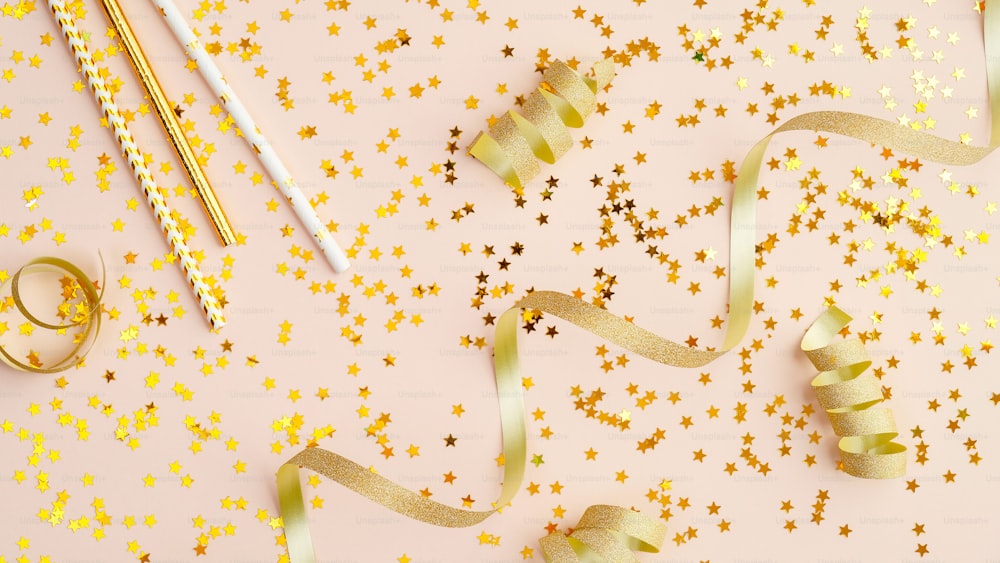 Stella di coriandoli d'oro e stelle filanti per feste su tavolo beige. Vista dall'alto dello sfondo della celebrazione. Concetto di Natale, compleanno o matrimonio.