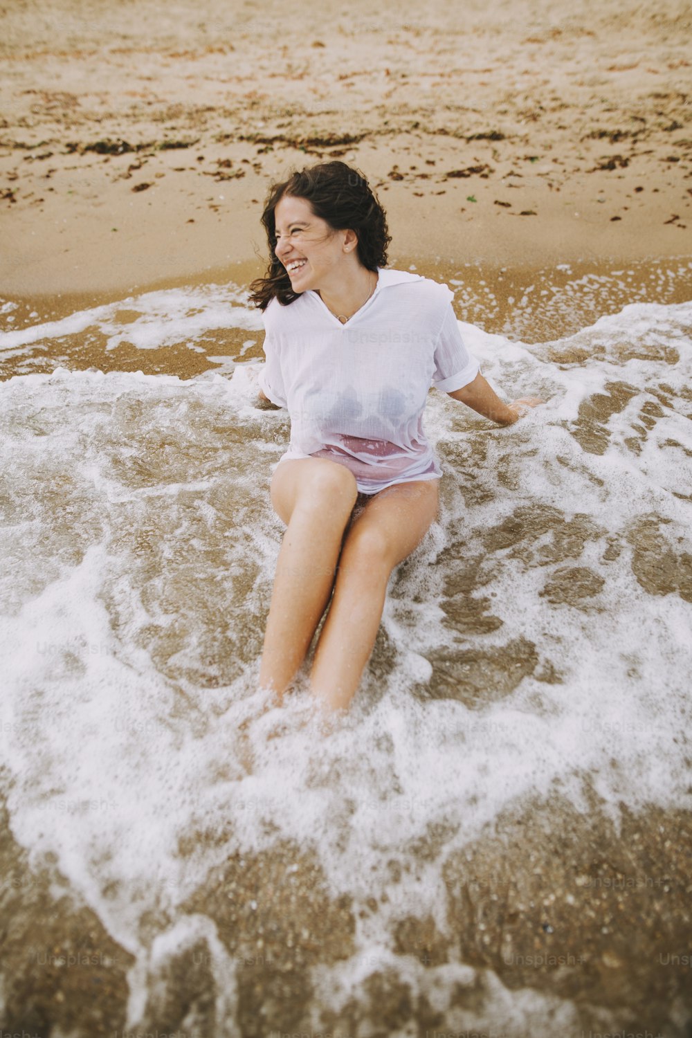 Happy young woman taking off wet white shirt on beach, back view. Stylish  girl in swimsuit relaxing on seashore. Summer vacation. Carefree moment  photo – Water Image on Unsplash