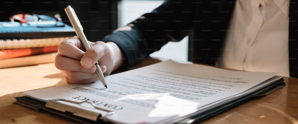 El agente de bienes raíces firma un acuerdo de documentos de contrato con el cliente para firmar el contrato.