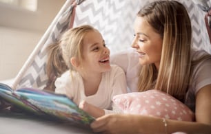 Great story mom. Mother and daughter in bed reading book.