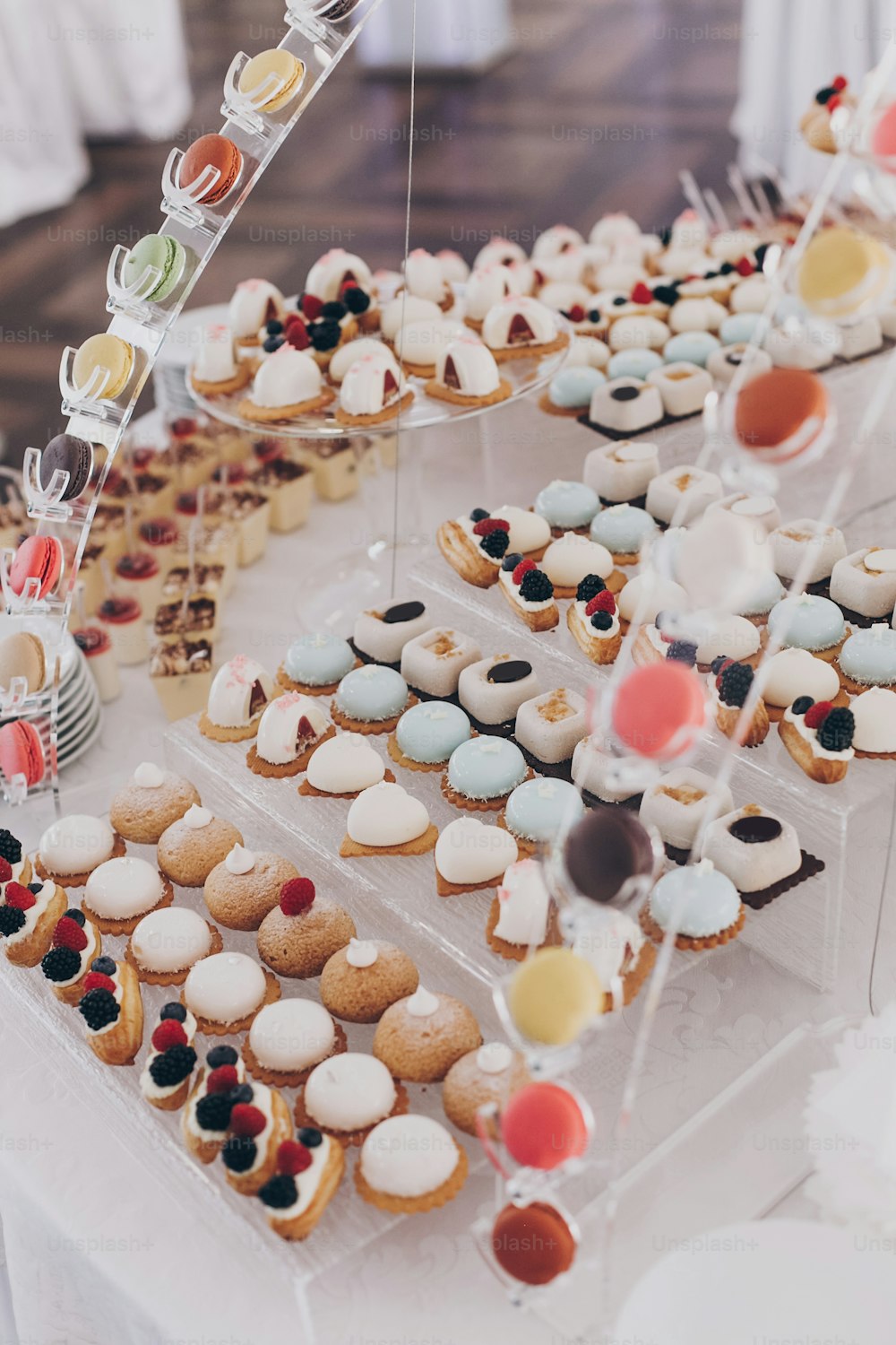 Deliziosi dessert cremosi con frutta, macarons, torte e biscotti sul tavolo al ricevimento di nozze nel ristorante. Servizio catering di lusso. Barretta di cioccolato nuziale.