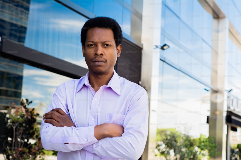 Portrait of young Afro American businessman standing outdoors at the street. Business concept.