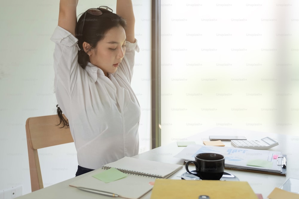 Businesswoman relaxing at comfortable in office hands behind head, happy woman resting in office satisfied after work.