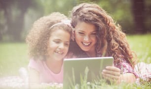 Technology is so fun. Mother and daughter in nature.