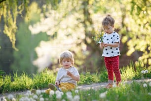 Front view of small children boy and girl playing outdoors in spring nature.