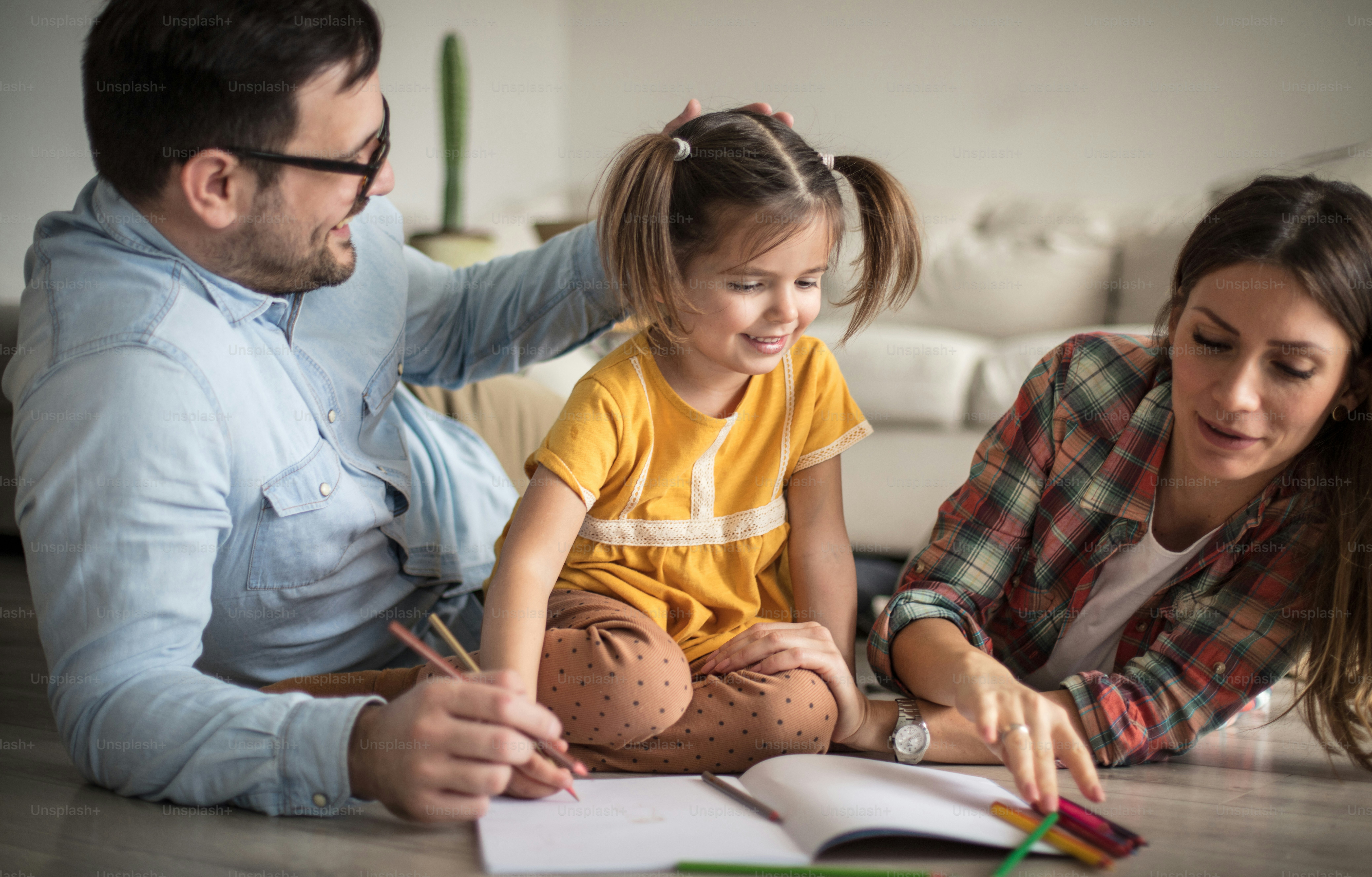 Parents helping their child with a learning activity at home as part of a shared family routine