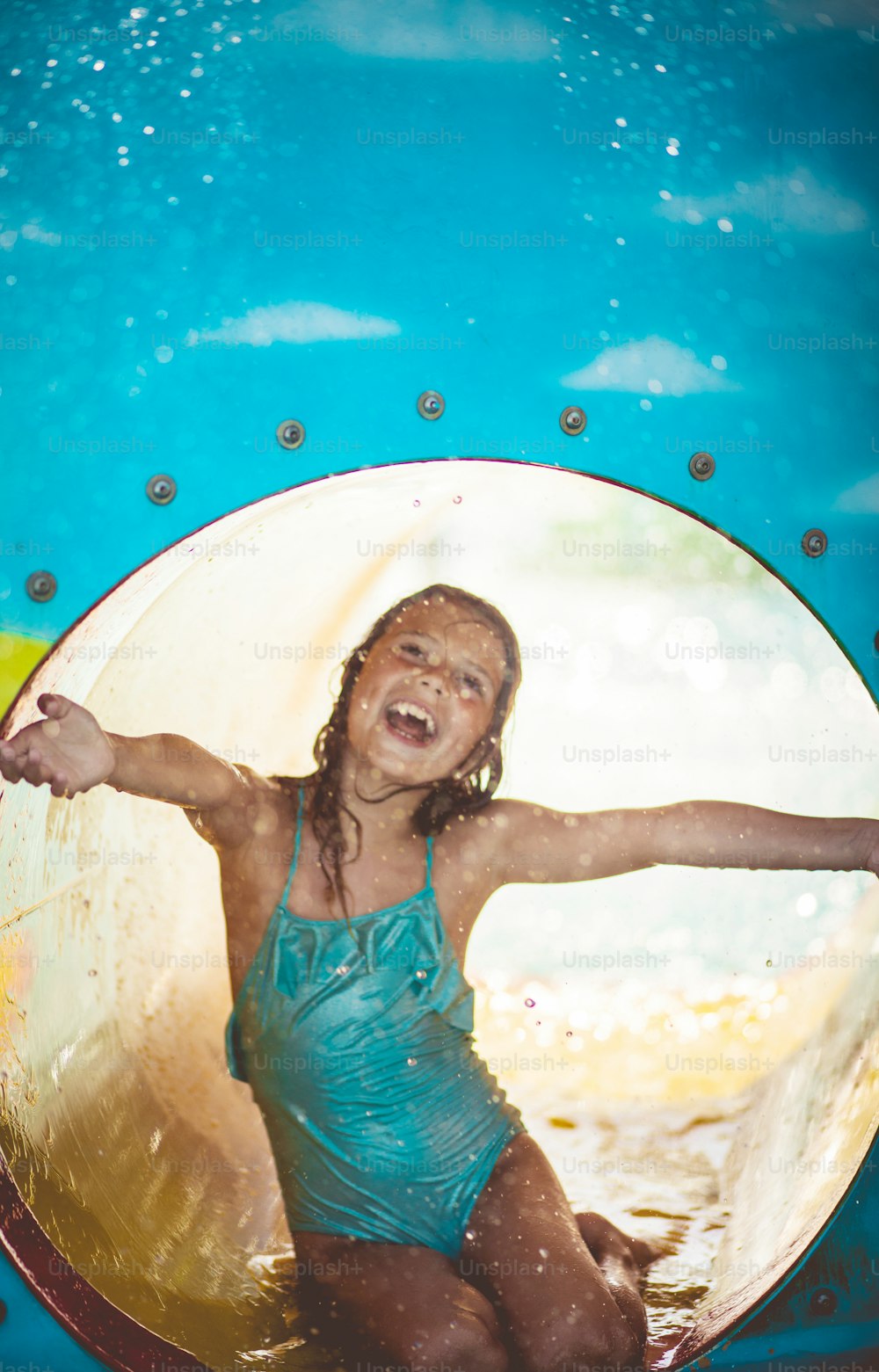 재미는 멈추지 않습니다. 수영장 터보건에서 즐거운 시간을 보내는 아이.
